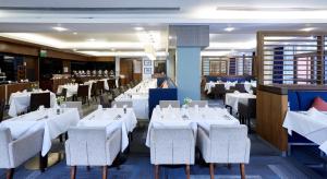 a dining room with white tables and chairs at Stamford Bridge Hotel London in London
