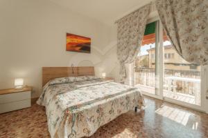 Un dormitorio con una cama y una ventana grande. en Casa Cristina - Goelba, en Porto Azzurro