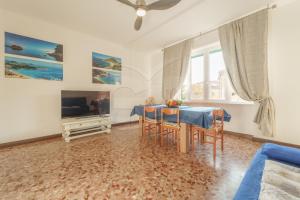 Una sala de estar con una mesa y un televisor. en Casa Cristina - Goelba, en Porto Azzurro