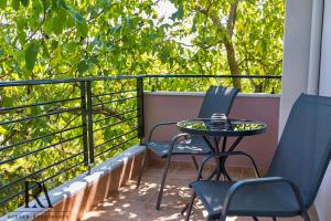 un patio avec deux chaises et une table sur un balcon dans l'établissement Roksen Apartments JUNGLE, à Ioannina