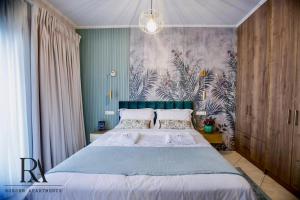 - une chambre avec un grand lit et un mur fleuri dans l'établissement Roksen Apartments JUNGLE, à Ioannina