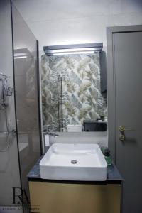 une salle de bains avec un lavabo blanc et un miroir dans l'établissement Roksen Apartments JUNGLE, à Ioannina 14 autres photos