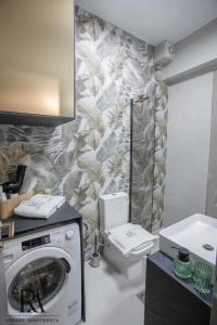 une salle de bains avec lave-linge et toilettes dans l'établissement Roksen Apartments JUNGLE, à Ioannina