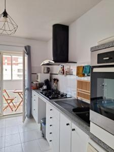 a kitchen with white cabinets and a stove top oven at Appartement T3 GEO ANDRE in Lormont
