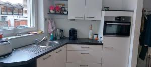 a kitchen with white cabinets and a sink and a window at Panoramalounge Moselblick - Toplage in Traben-Trarbach