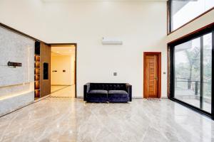 a living room with a couch in the middle of a room at Hotel O DEVOM INN in Greater Noida