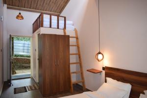 a bedroom with a bunk bed and a ladder at Treecasa Resort in Sunāri