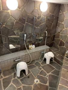 a stone bathroom with two toilets and a shower at Yotei no Sato in Niseko +22 photos