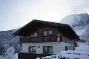 a house with a balcony in the snow at Ferienhaus Bucheggerhof in Schladming +20 photos