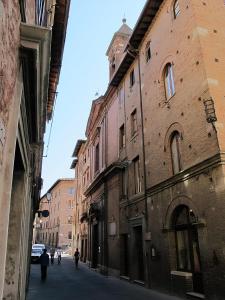 an alley with buildings and people walking down a street at Perla moderna nella natura in Siena