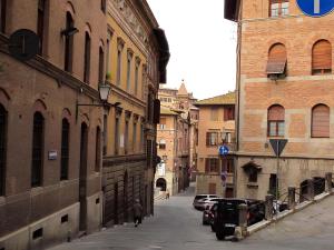 an alley with buildings and a car parked on a street at Perla moderna nella natura in Siena