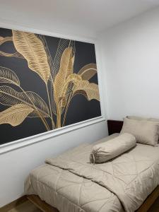 a bed in a room with a painting on the wall at villa Elfame Lokon in Tomohon