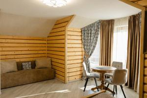 a living room with a couch and a table at Zatyshok nad Prutom in Bukovel