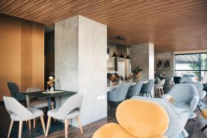 a restaurant with blue and white chairs and tables at Rise Urban Art Hotel in Larnaca
