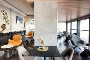 a waiting room with chairs and tables and a lobby at Rise Urban Art Hotel in Larnaca