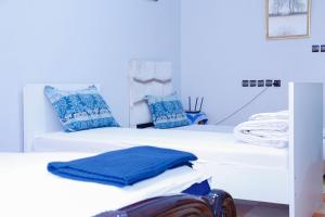 two white beds with blue pillows in a room at Elhachimi two bedroom with air conditioning in Er Rachidia +84 photos