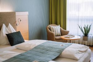 圣兰布雷希特Hotel Auszeit St Lambrecht的一间带床和椅子的酒店房间