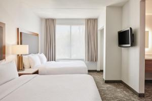 una camera d'albergo con due letti e una tv di SpringHill Suites Phoenix Downtown a Phoenix