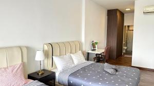 丹绒道光LM HomeyC 3BR Family Suite for 4-14 Pax with Nexflix & Coway Water Purifier的一间卧室，配有一张床和一张带灯的书桌