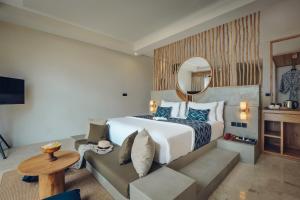 una camera d'albergo con un letto e un divano di The Sebali Penida Beach Resort a Nusa Penida