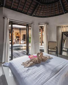 a bedroom with a large bed with a woman laying on it at Sandi Kala Villas in Kerobokan