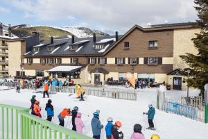 a group of people in the snow in front of a building at Hotel Port 1730 in La Coma i la Pedra