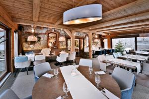 a restaurant with wooden ceilings and tables and chairs at APLEND Hotel Kukučka in Tatranská Lomnica