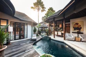 a house with a swimming pool in the yard at Sandi Kala Villas in Kerobokan