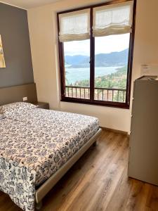 a bedroom with a bed and a large window at NEW Luxury Apartment - Menaggio in Menaggio