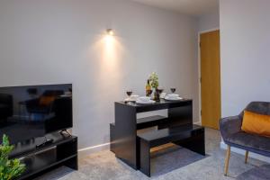 a living room with a black table and a tv at Vibrant 2 Bed Apartment, FREE Parking, Bawtry Rd Doncaster - Hosted by Stay Host Save in Doncaster