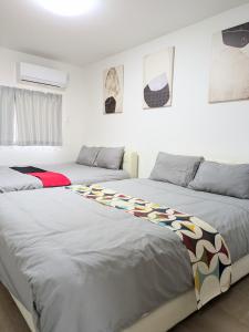 two beds in a room with white walls at 桃谷駅から1分 一軒家 大阪MD Goodfellas inn Osaka MD in Osaka