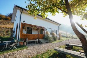 a small white house with a table and chairs at CHRISTE FOREST RETREAT Bed & Chocolate in Floreşti