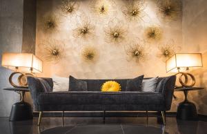 a couch in a room with flowers on the wall at Rise Urban Art Hotel in Larnaca