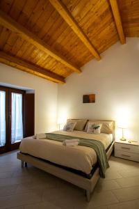 a bedroom with a large bed with a wooden ceiling at Le tre Spighe - Affitti Brevi Italia in LʼAquila