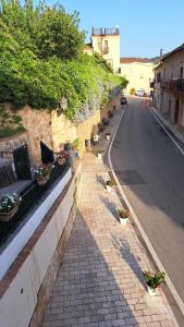 eine leere Straße mit Topfpflanzen auf einem Ziegelsteinweg in der Unterkunft Casa Particolari nel Cilento in Giungano