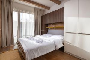 Un dormitorio con dos camas y una gran ventana. en TRITA SK - Apartmán Hrebienok resort 108 - Central location - Garage parking, en Starý Smokovec
