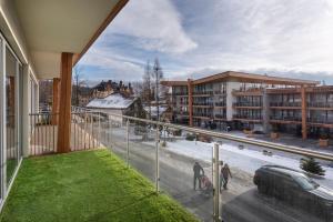 Un balcón con vista a una calle y edificios. en TRITA SK - Apartmán Hrebienok resort 108 - Central location - Garage parking, en Starý Smokovec