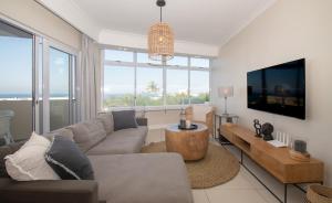 un salon avec un canapé et une télévision dans l'établissement 14 Sea Lodge Umhlanga Rocks, à Durban