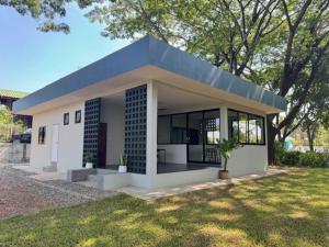 a small white house with a blue roof at Mon Tresor Garden มง เทร ซอ in Amphoe Sawang Daen Din