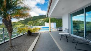 Casa con balcón con palmeras y piscina en Estrela do Mar - by LovelyStay - Lovely, Sun Filled Villa, en Calheta