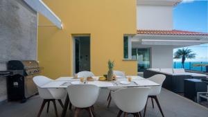 comedor con mesa, sillas y parrilla en Estrela do Mar - by LovelyStay - Lovely, Sun Filled Villa, en Calheta