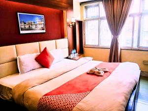una camera d'albergo con un grande letto con scarpe di Hotel Shraddha Palace a Kathmandu