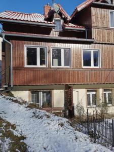 a wooden house with snow on the ground at Pokoje gościnne Kamil 3 in Karpacz +1 photo