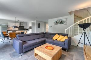 a living room with a blue couch and a table at Zwanebloem 2 in Cadzand