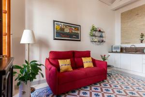 a red couch with two yellow pillows in a living room at MCH-Marina Charming House in Cagliari