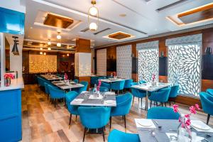 a restaurant with blue tables and blue chairs at The Golden Apple in Lucknow