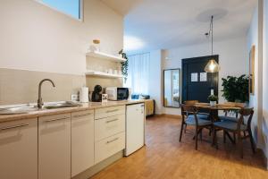 a kitchen with white cabinets and a table with chairs at Charming Apartment in the Heart of Triana, Seville in Seville +13 photos