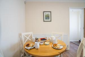a wooden table with plates of food on it at Little Hill Farm Villa in Ringwood