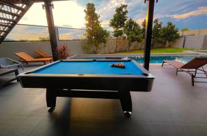 a pool table in front of a swimming pool at BangTao 6-bedroom villa 18 meters, competition-grade swimming pool, industrial style design aesthetic, gaming and entertainment floor, suitable for family vacations and group gatherings in Laguna Phuket