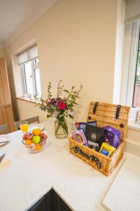 a kitchen counter with baskets of food and a vase of flowers at Little Hill Farm Villa in Ringwood